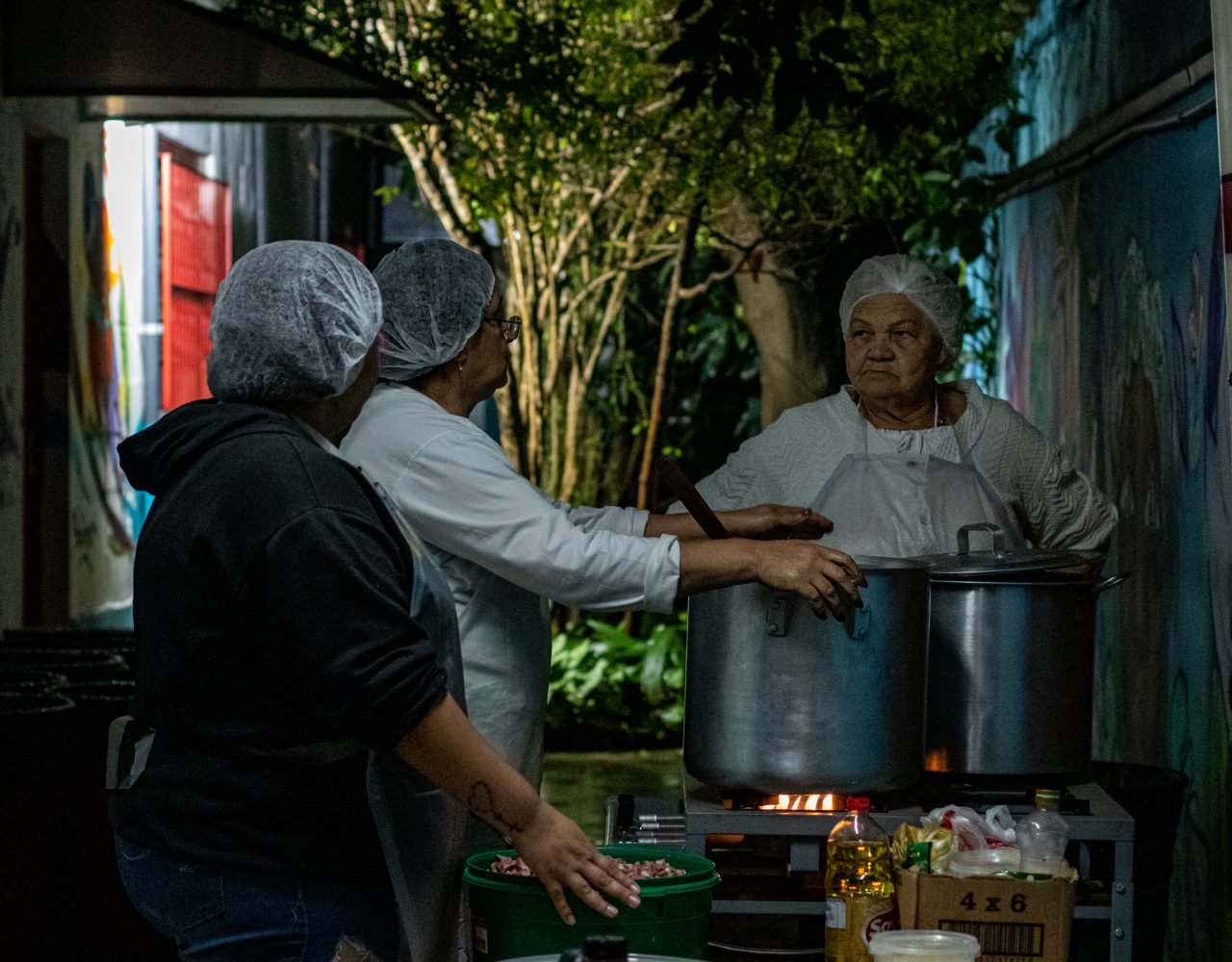 Mãe Lurdes e as filhas de santo Helena e Jaqueline, do Terreiro Caboclo Sete Flechas, são as responsáveis pela preparação do prato da noite