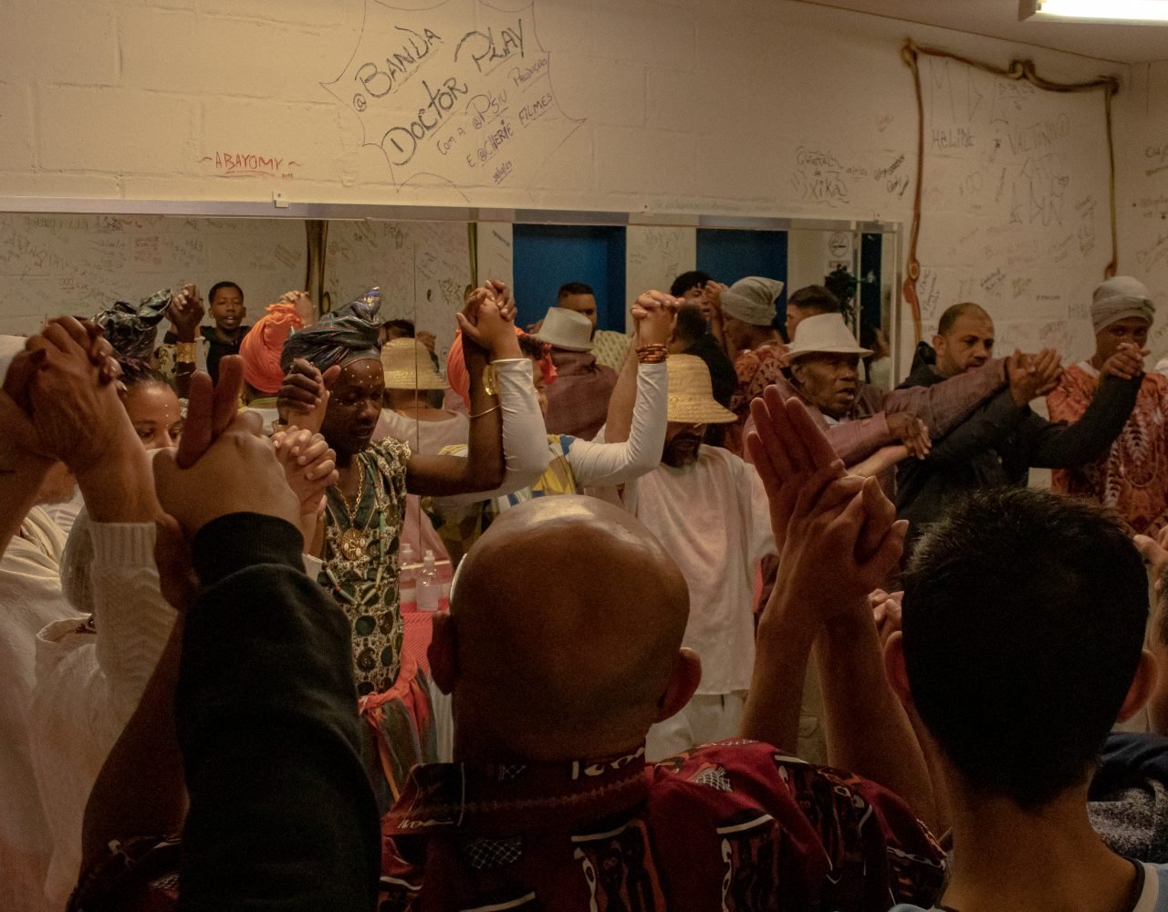 Antes da abertura, o grupo se reúne para celebrar mais um evento sendo iniciado