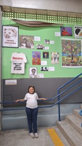 Luiza Aparecida, 8 anos, em frente à parede com trabalhos de estudantes (foto André Santos)