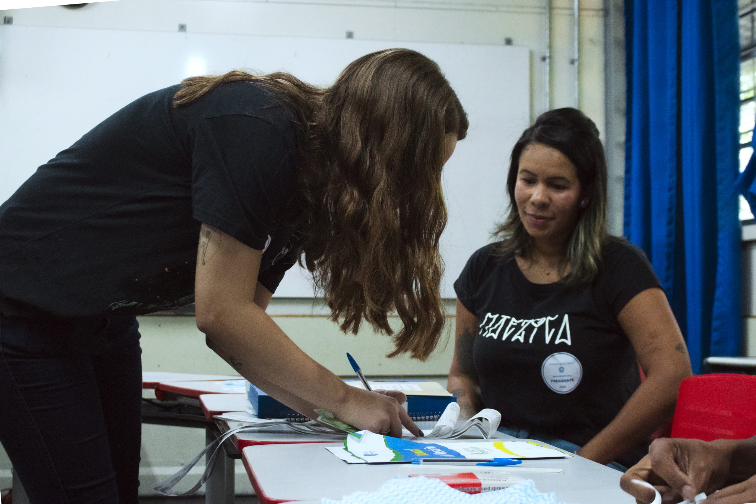 Thamiris atende eleitora durante votação no primeiro turno em São Paulo (foto Pedro Salvador)