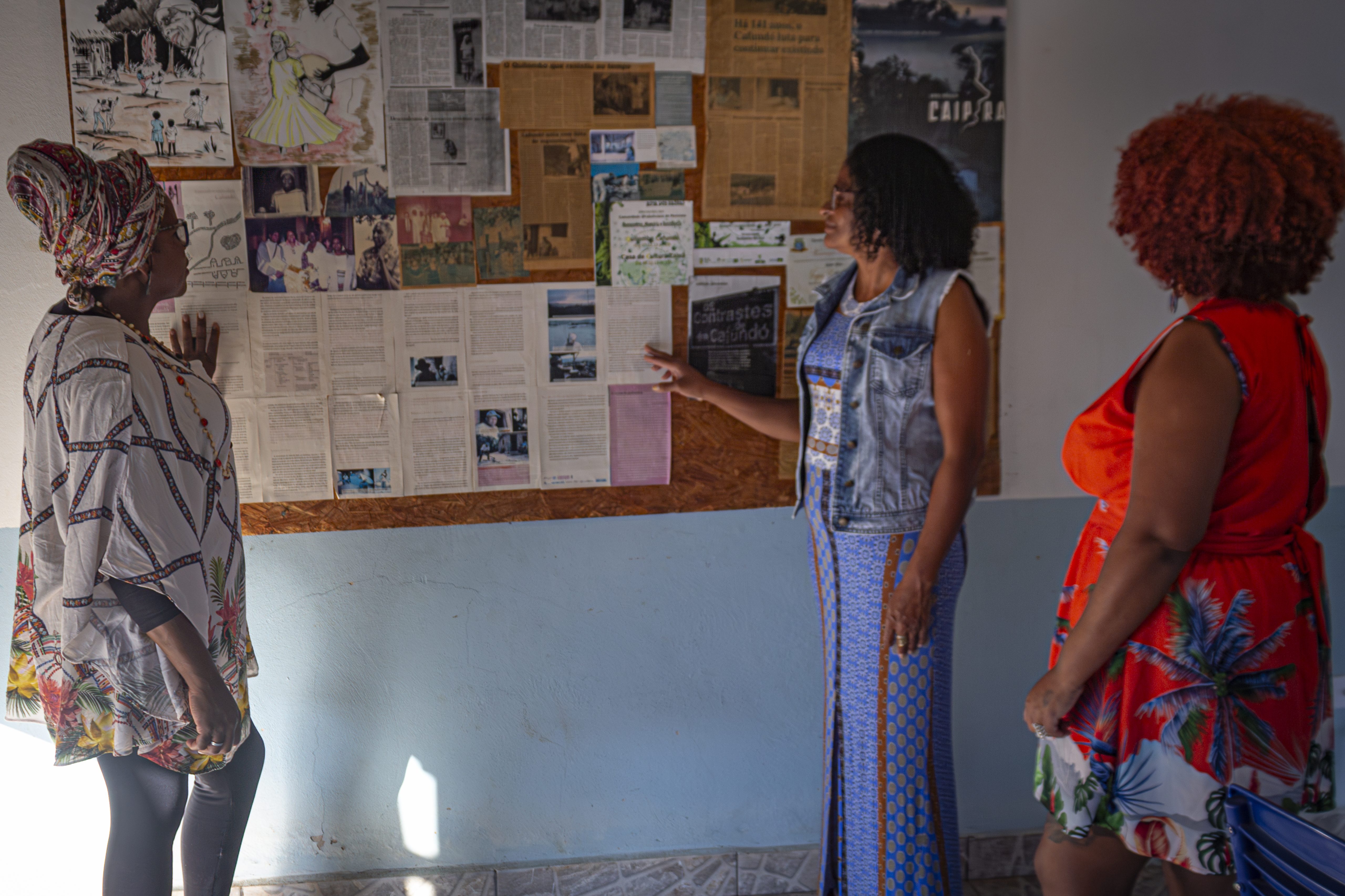 Da esquerda para a direita: Luciana Rosa de Aguiar Lima, Lucimara Rosa de Aguiar e Lucilene Rosa de Aguiar apresentando o mural com imagens, desenhos, reportagens contando a história do Quilombo.  (Foto: Mapy Barbosa)
