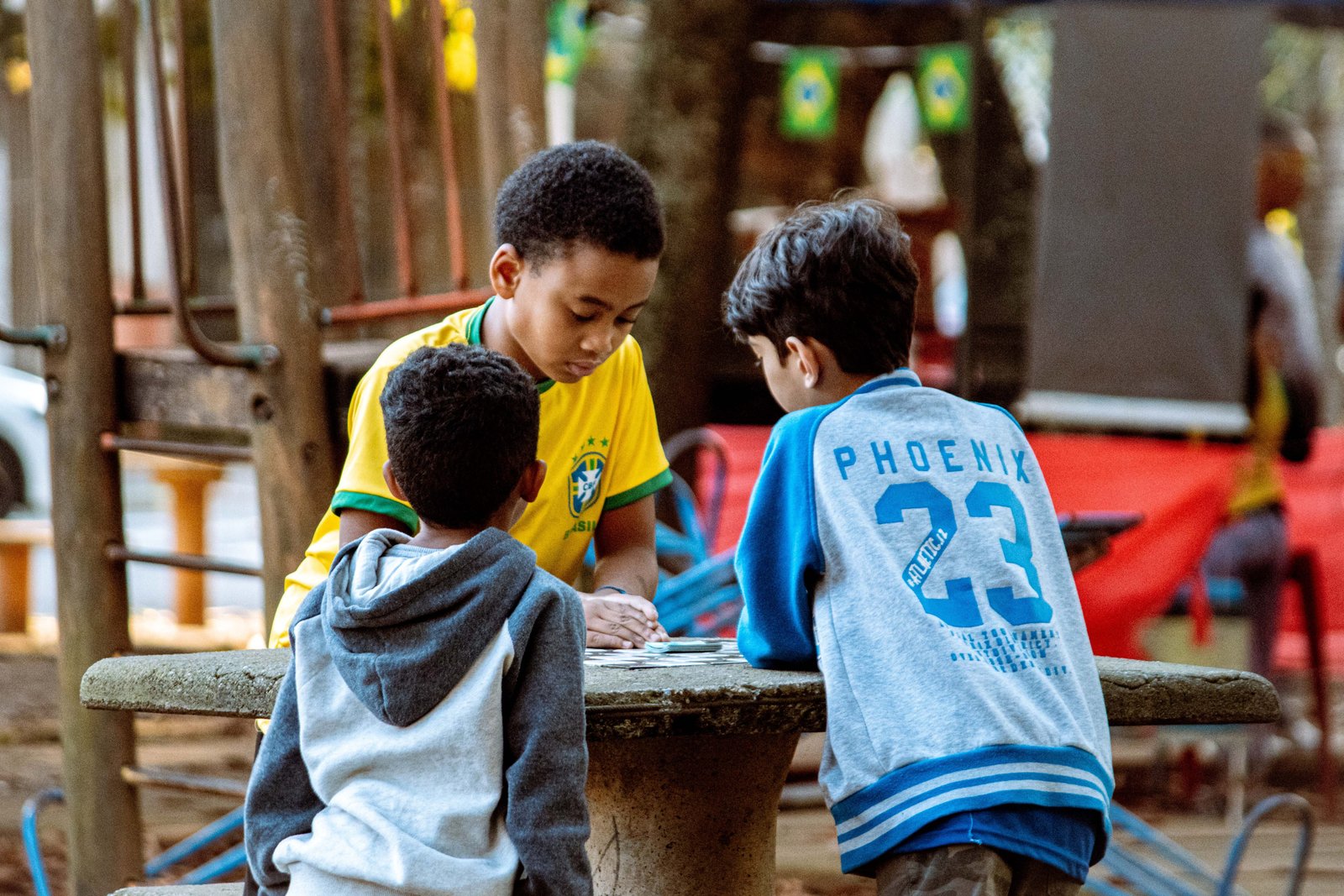 Crianças brincam de bafo com figurinhas da Copa