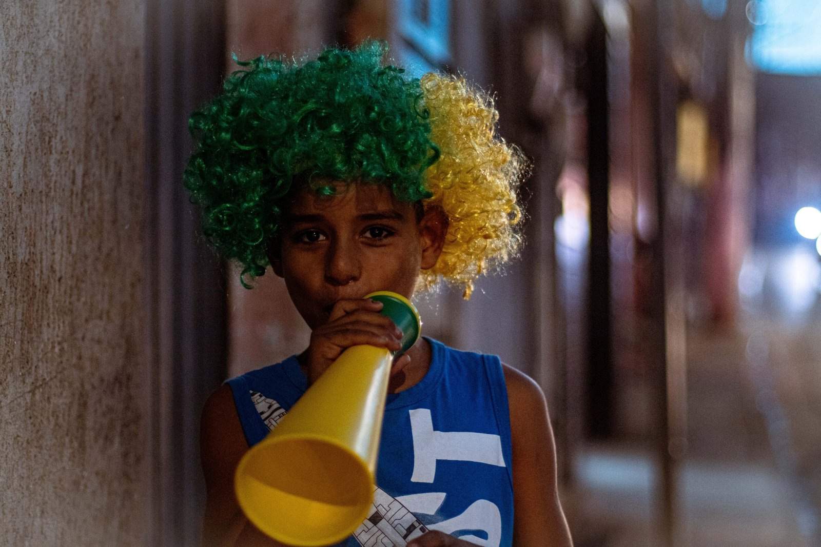 Criança com peruca verde e amarela toca vuvuzela na avenida Belmira Marin, que corta o distrito no Extremo Sul